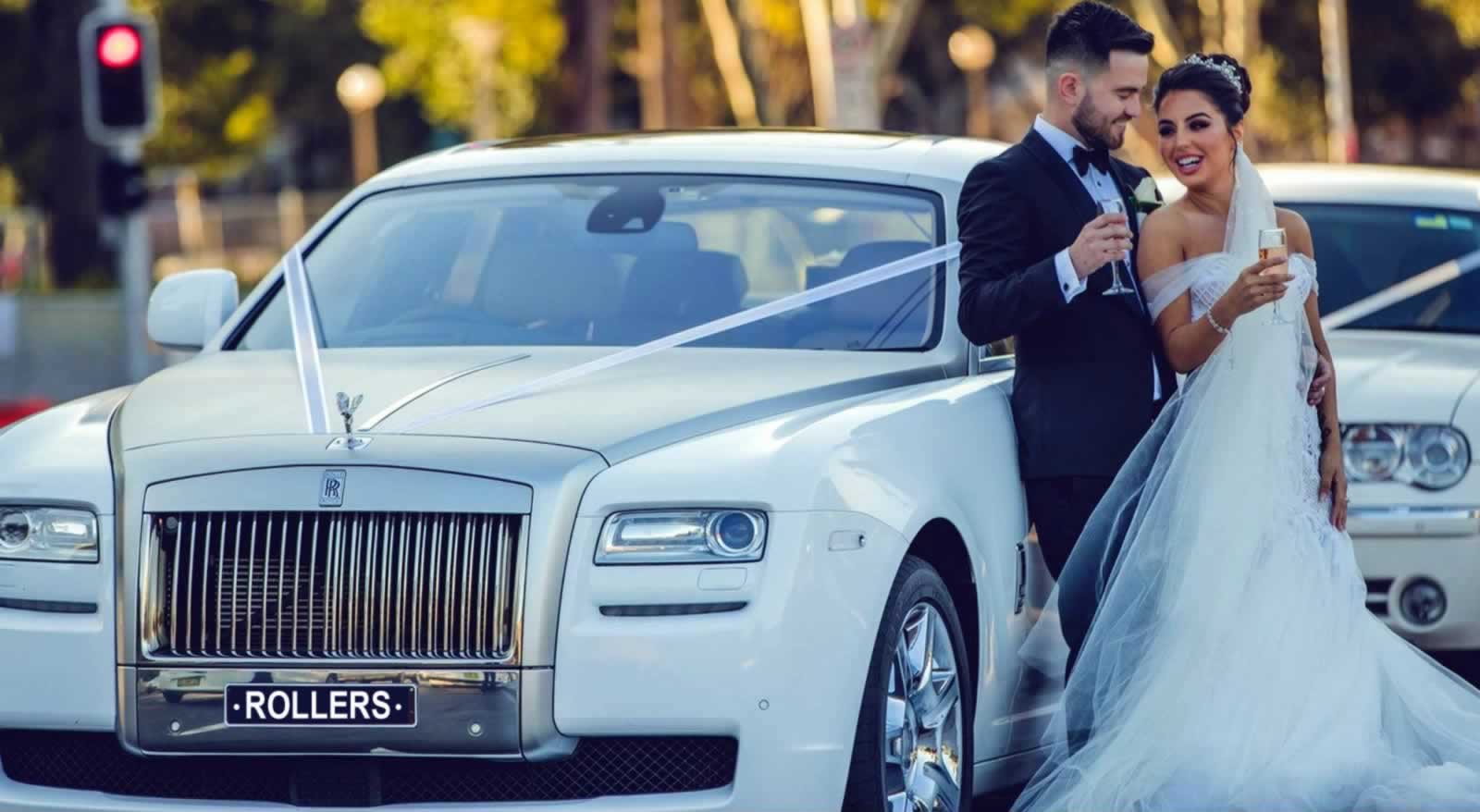 Bride and standing beside a white Rolls Royce Ghost wedding car